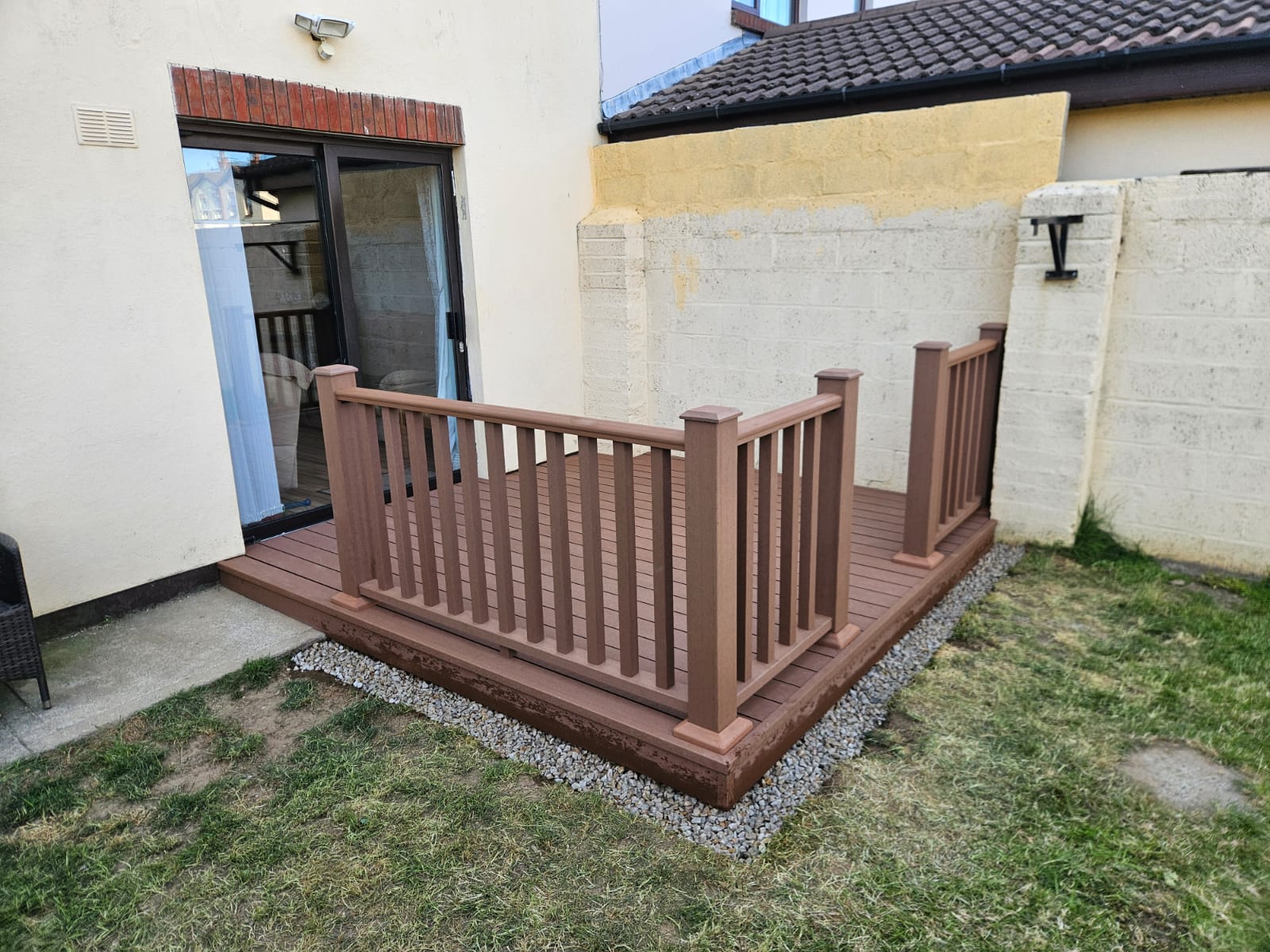 After photo showing beautiful mahogany composite deck with railings