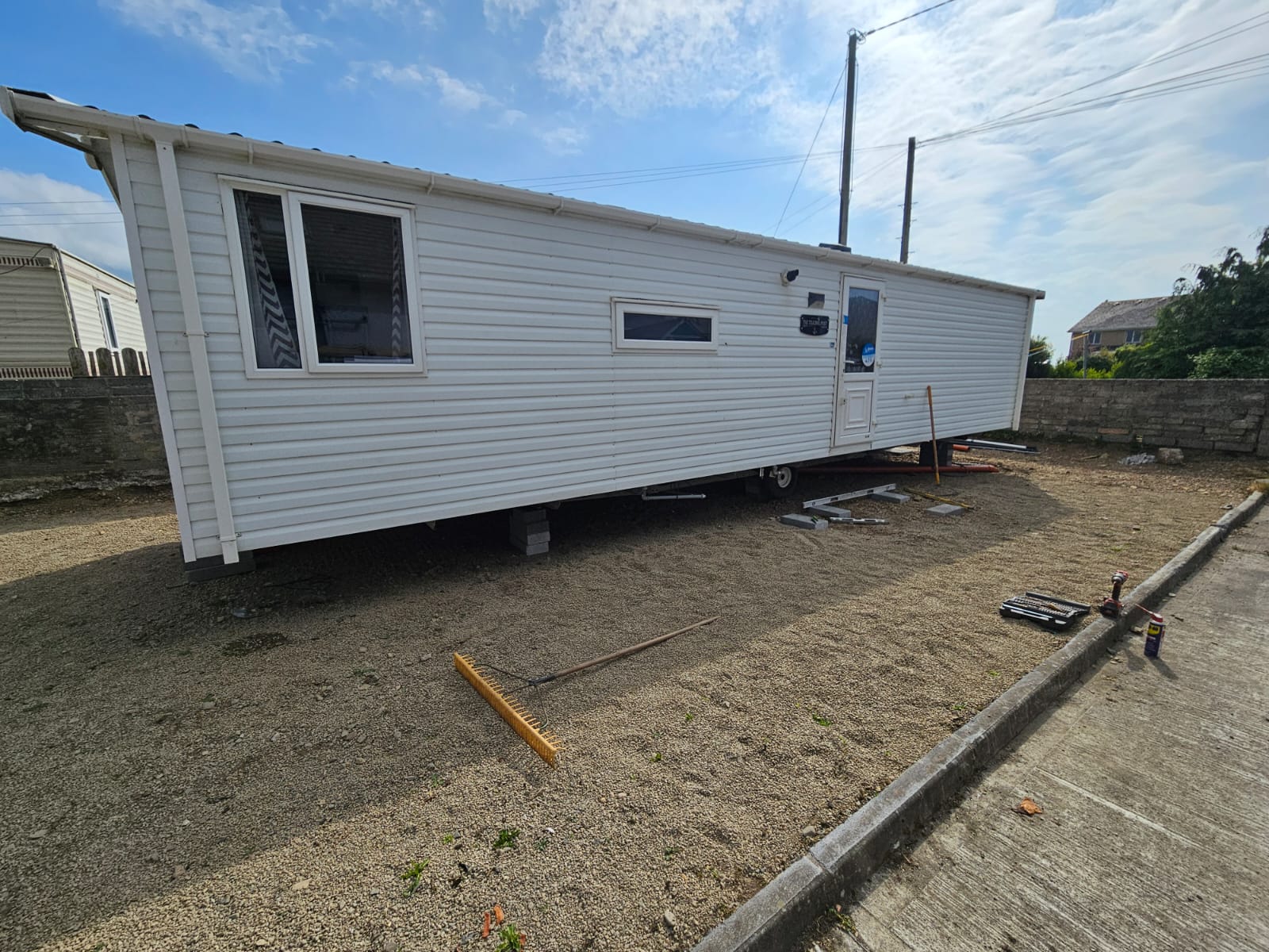 Mobile home site before preparation showing uneven ground and access challenges