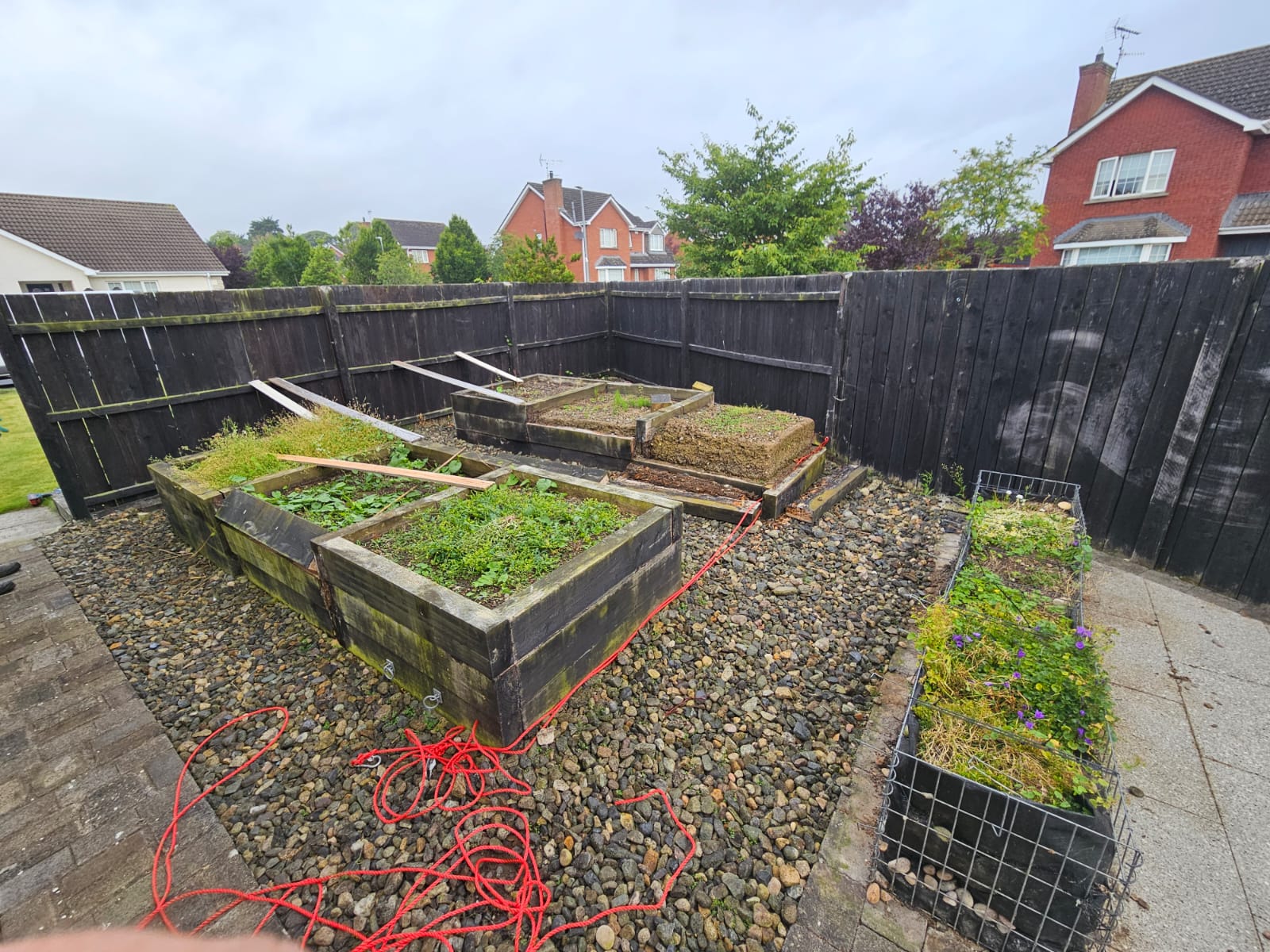 Before photo showing basic garden area with existing structures